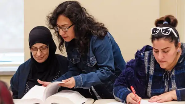 Tre kvinnor studerar tillsammans vid ett bord - på kurs i kurdiska på Folkuniversitetet