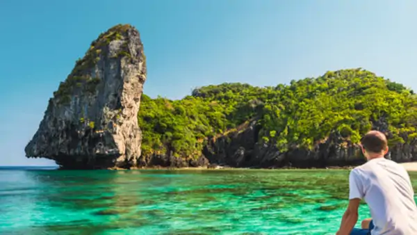 Deltagare njuter på en traditionell tråbåt i turkost hav - efter kurs i thailändska