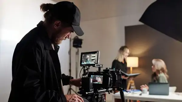 Deltagare filmar med professionell kamera under filmkurs i studio på Folkuniversitetet