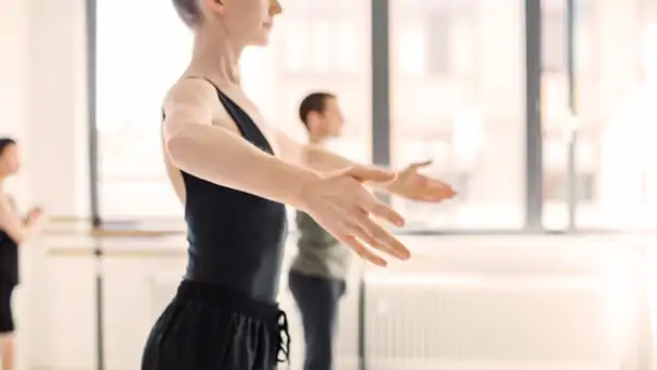 Deltagare i mörka danskläder som dansar balett
