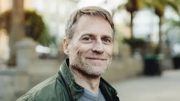 Leende man i grön jacka i utomhusmiljö - på kurs i estniska!