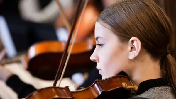 Ung violinist övar på fiolkurs hos Folkuniversitetet